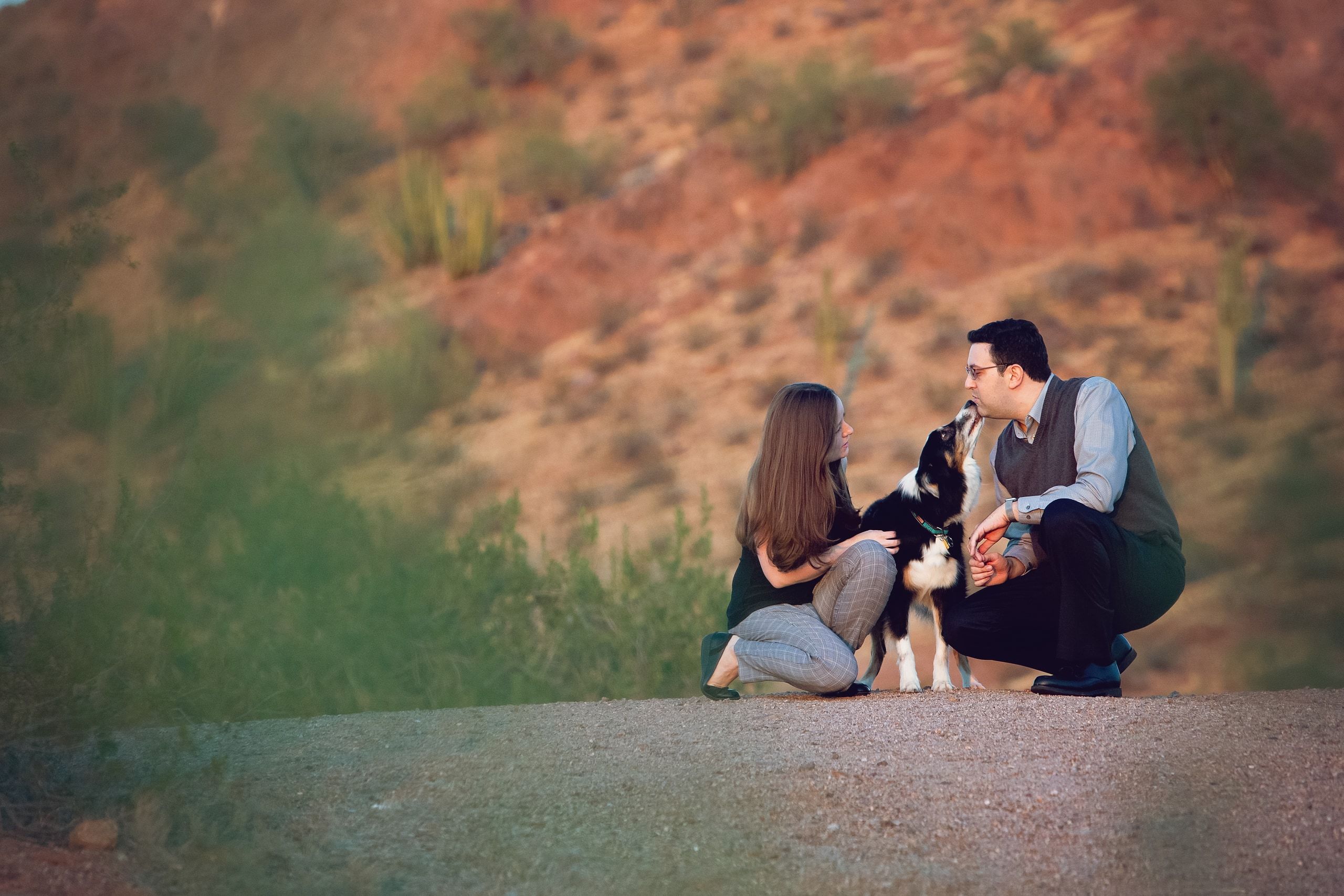 Dr. Berman and Dr. Kitchen with their dog on a wide Sonoran desert hillside at dusk